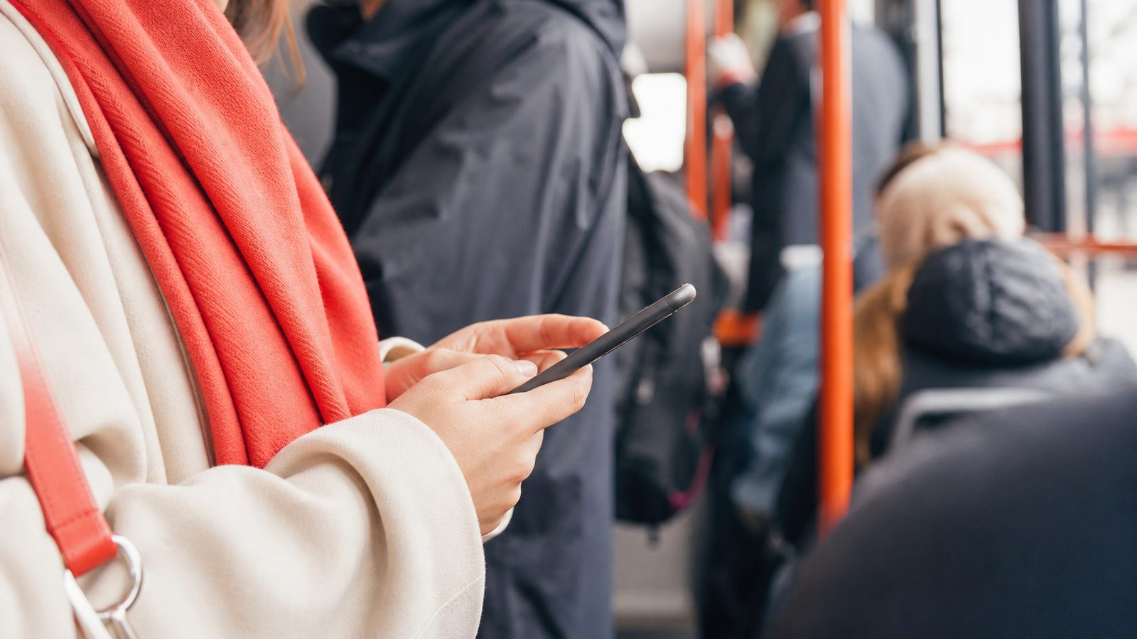 Osoba robi zakupy w telefonie jadąc komunikacją miejską